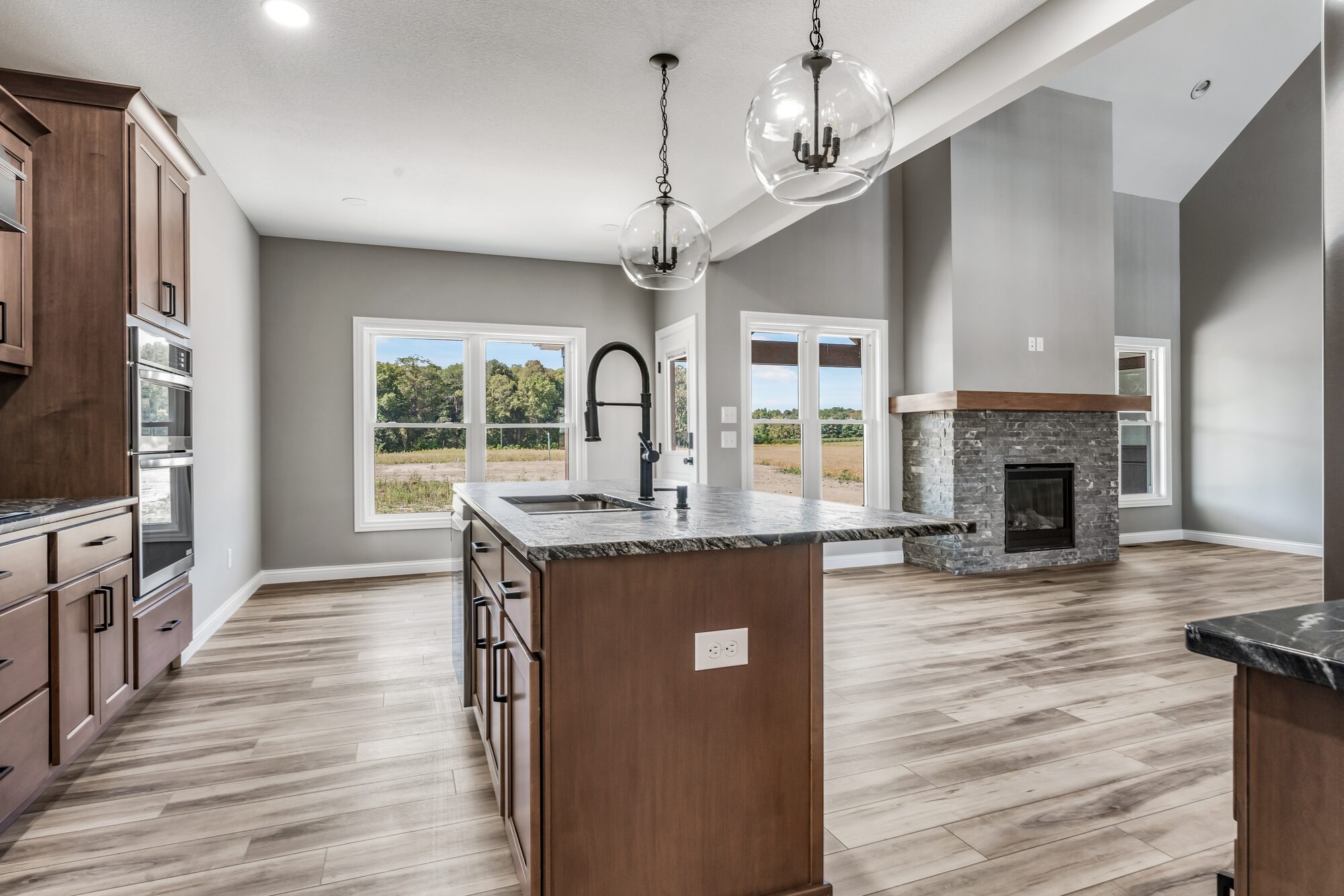 Custom kitchen with quartz island and brass pendants
